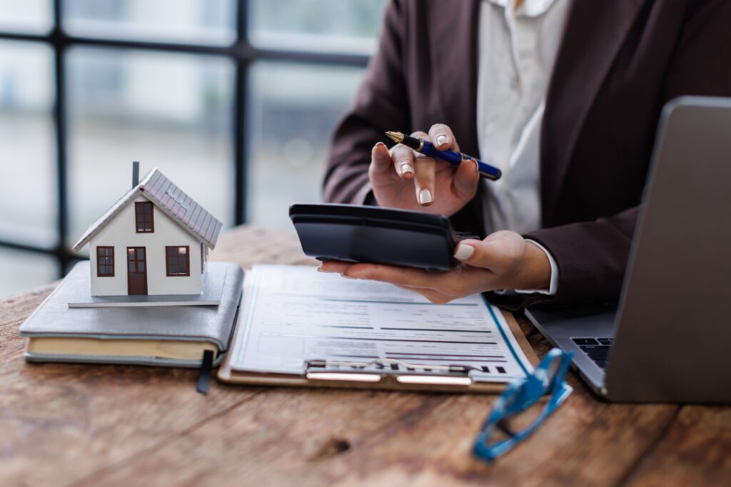Taschenrechner, Hausunterlagen und Stift bei der Immobilienbewertung